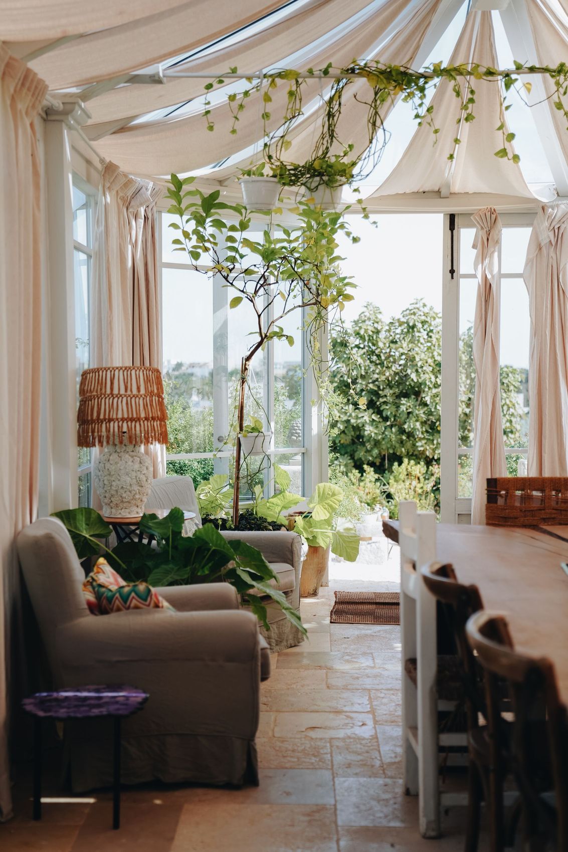 A conservatory furnished with cane chairs and plants