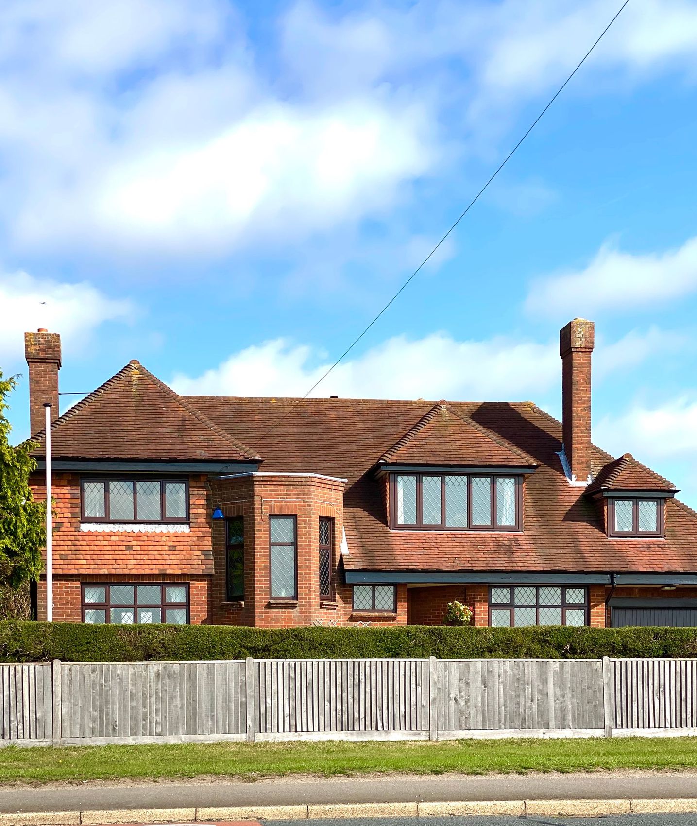 A red brick semi-detached house with white guttering