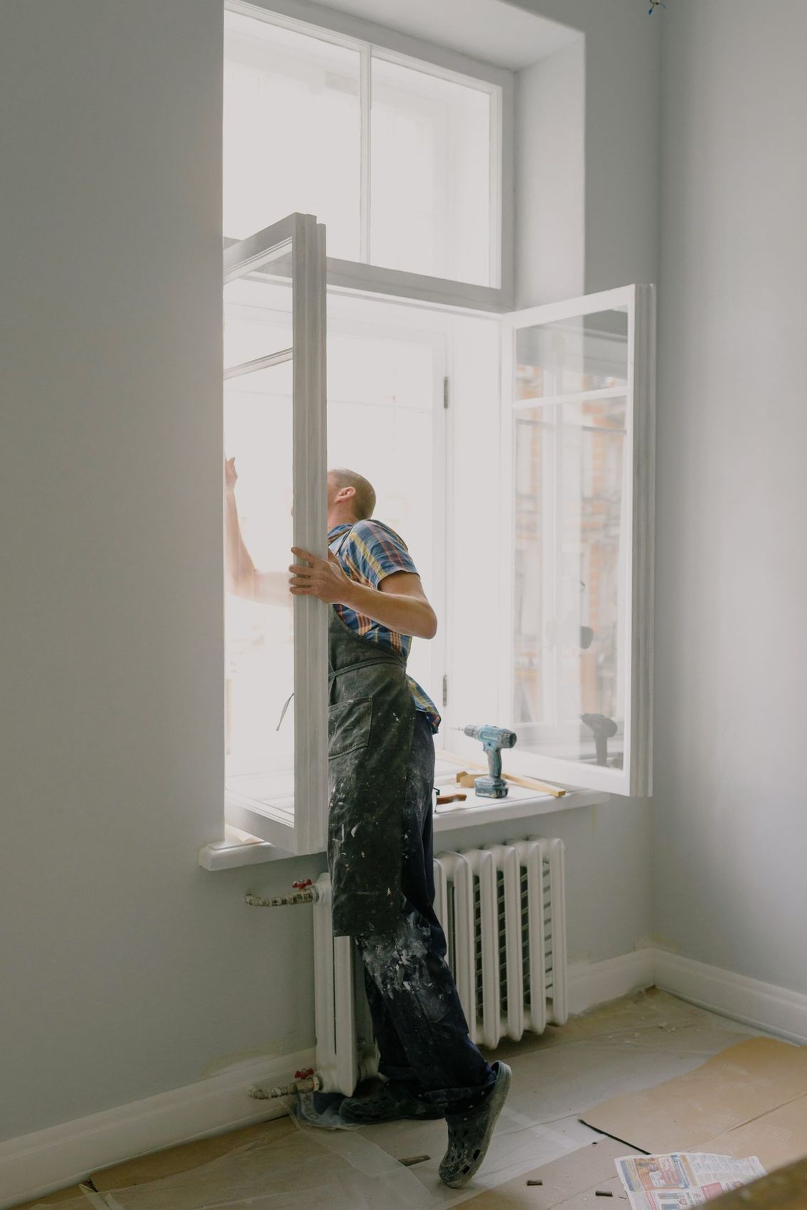 A fitter working at a window opening inside a property