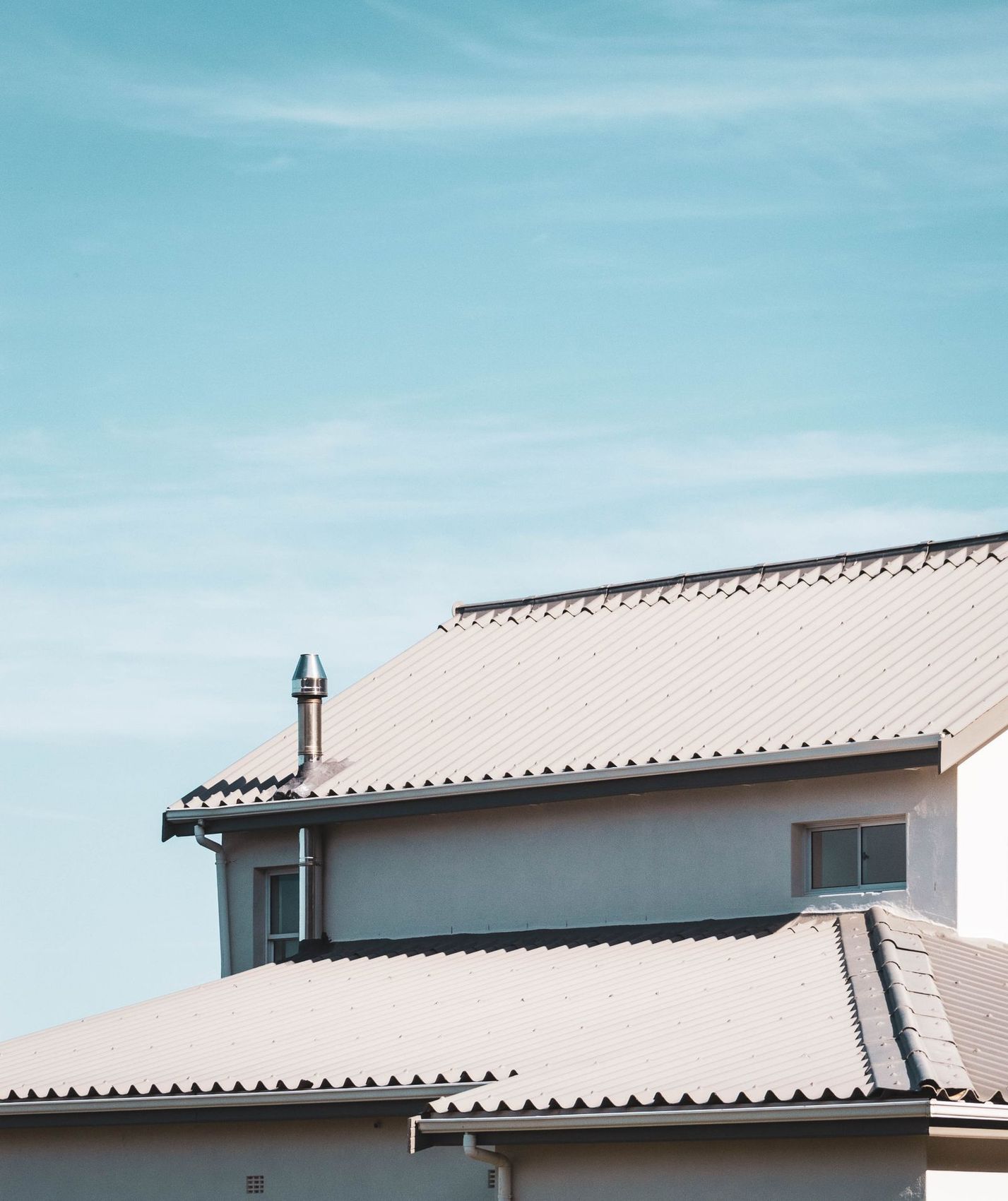 A tiled roof and chimney stack seen against the sky