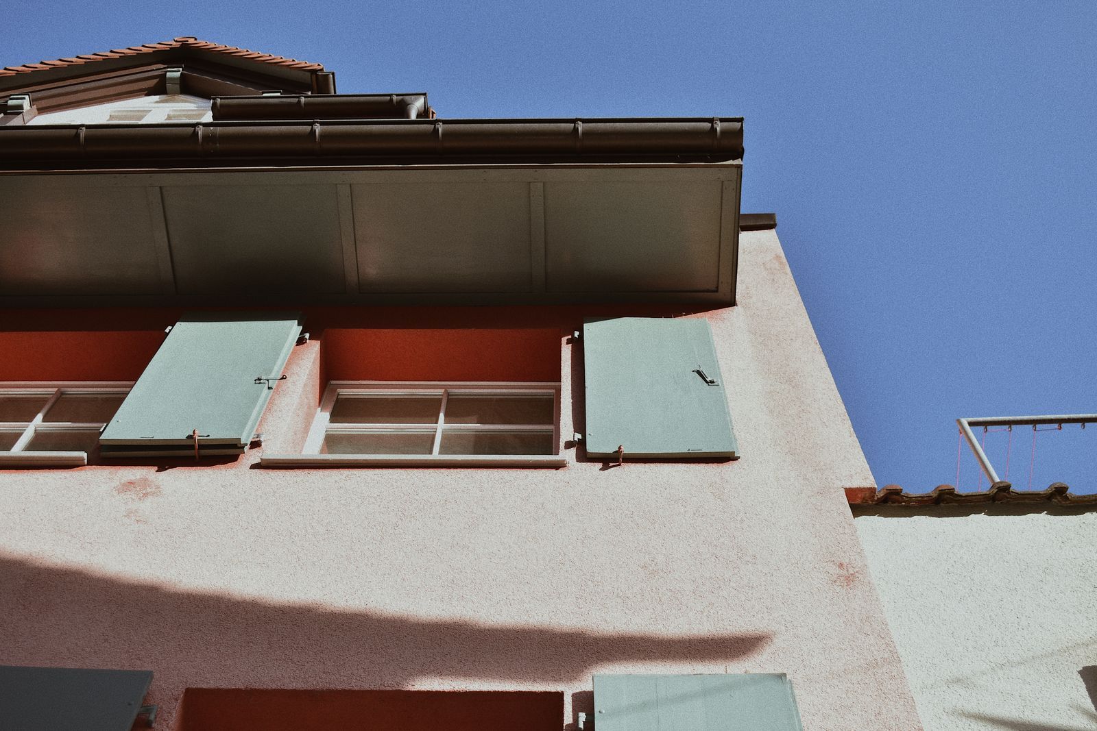 Eaves and guttering against a clear blue sky