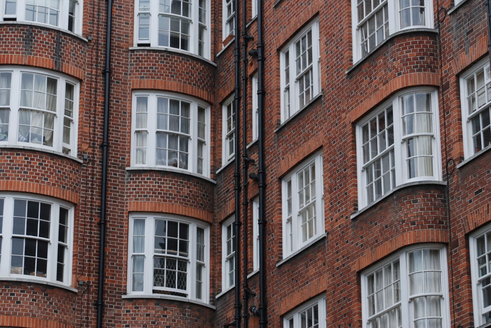 A red brick mansion block with curved bay windows